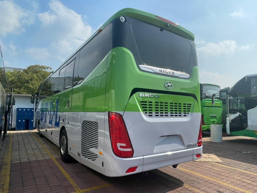 Rear view of a white and green B.T.L.L. Higer bus