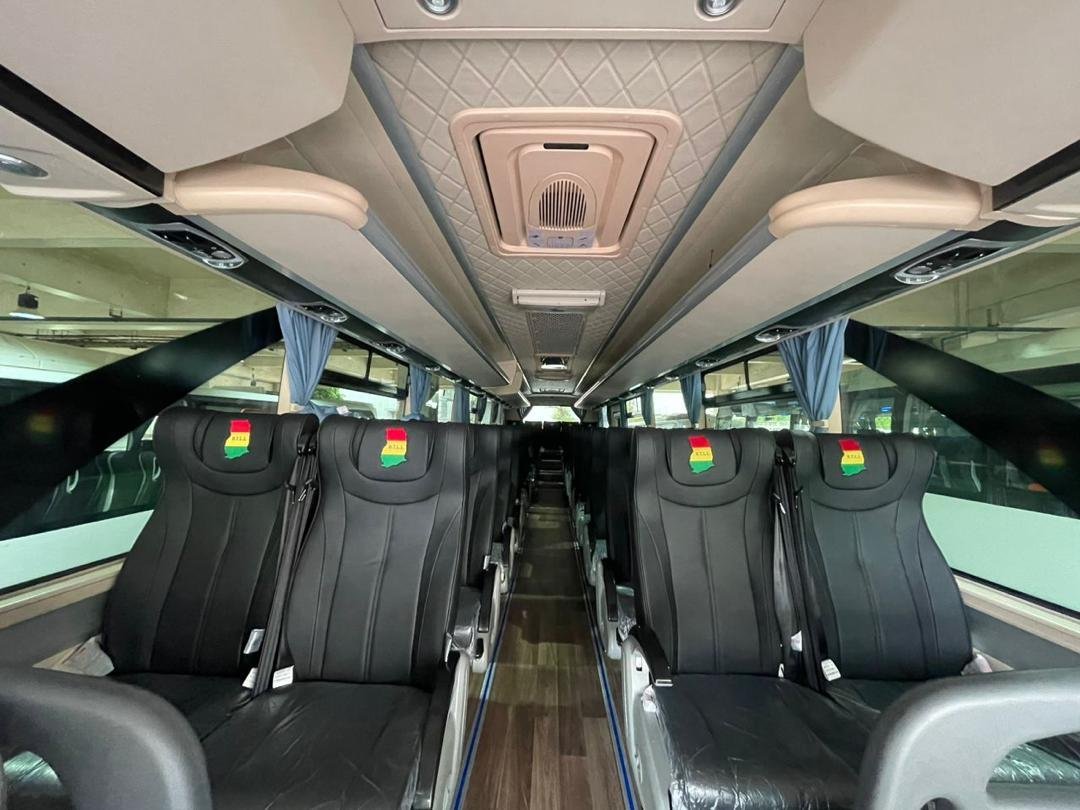 Inside a B.T.L.L. bus with cushioned seats and Ghana flag headrest covers
